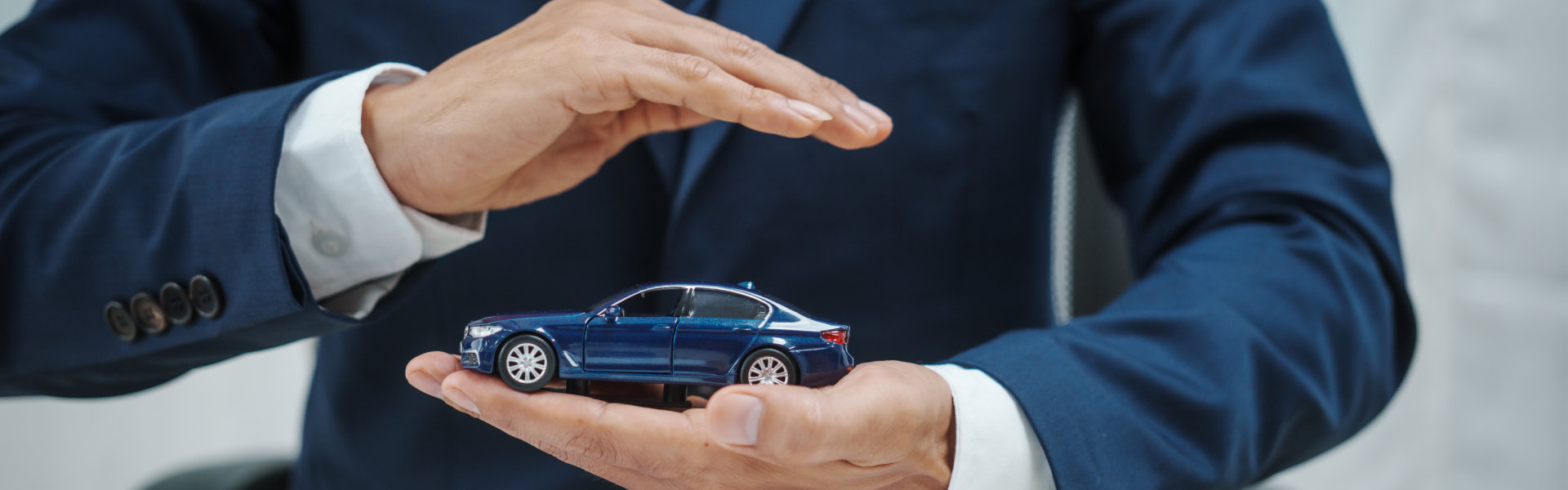 A hand holding a toy car