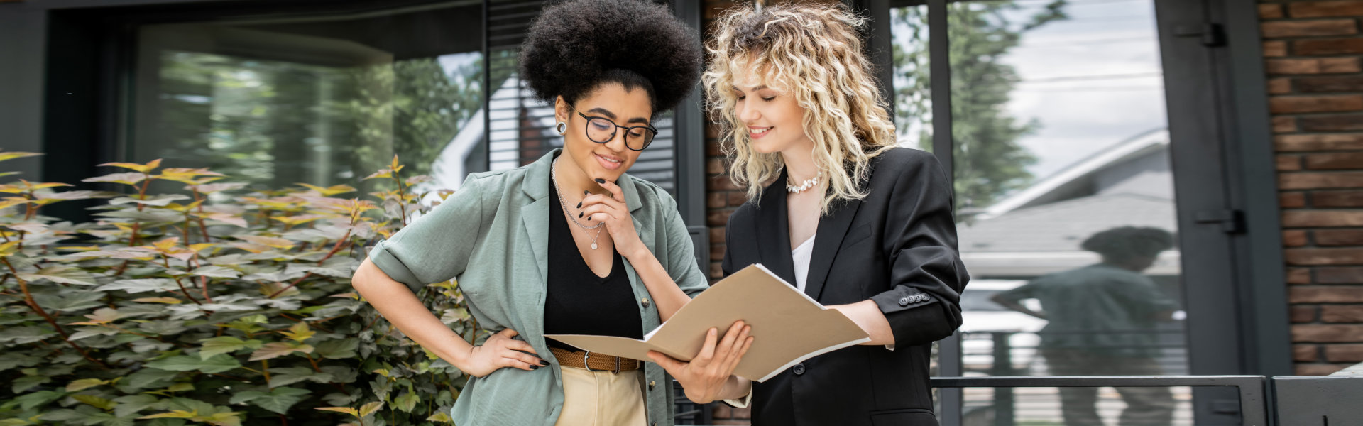 Businesswomen Reviewing Documents Outside an Office Building
